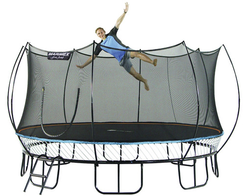 Freistehendes Gartentrampolin mit Sicherheitsnetz und Leiter, auf dem eine Person springt