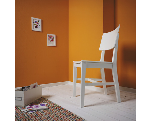 Pièce lumineuse avec chaise en bois, tableaux et boîte de rangement