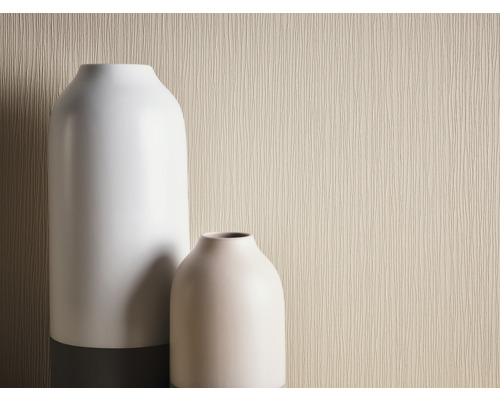 Gros plan de deux vases devant un papier peint beige texturé.