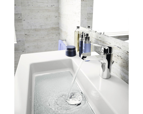 Salle de bains moderne avec lavabo, robinet et produits de soins