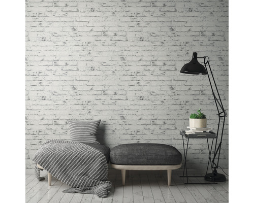 Ambiance d''habitation décorative avec papier peint à motif de briques, siège, lampadaire et table d''appoint.