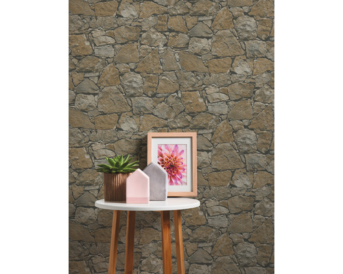 Papier peint à motif de pierre derrière une table avec décoration