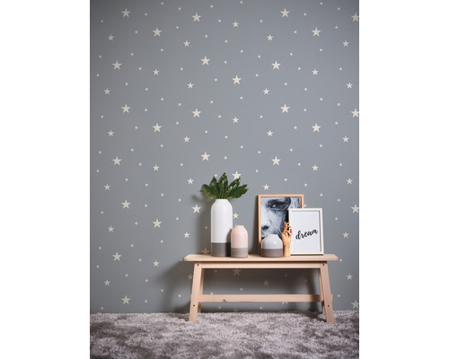 Pièce avec papier peint étoilé, banc et objets de décoration.