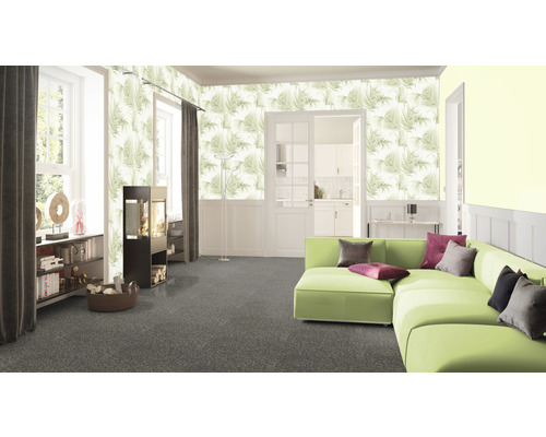 Salon avec papier peint à motifs, canapé vert et moquette