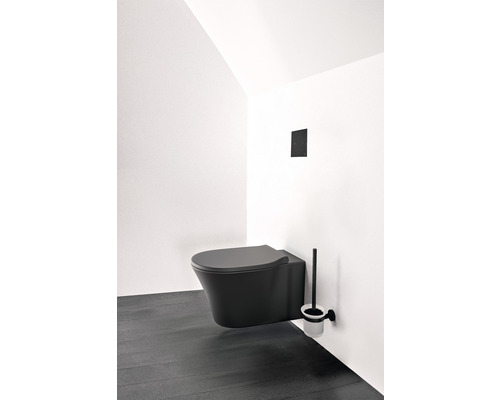 Wandhängendes WC mit Toilettenbürste in einem hellen Raum.