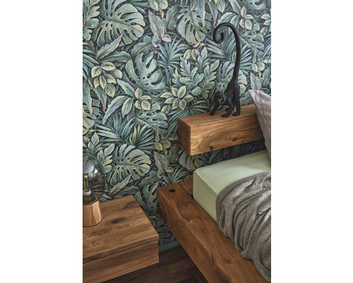 Schlafzimmer mit Dschungeltapete, Holzbett und Nachttisch