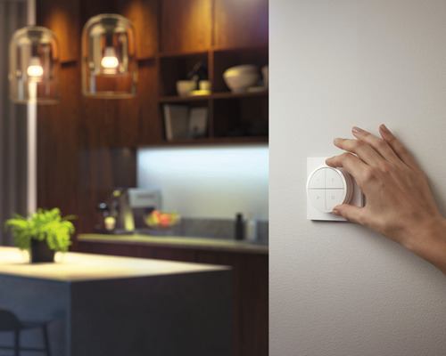 Eine Hand bedient einen Lichtschalter in einem modern gestalteten Raum.