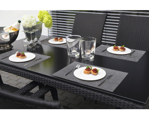 Table de jardin dressée avec nourriture, boissons et décorations pour un repas en plein air.