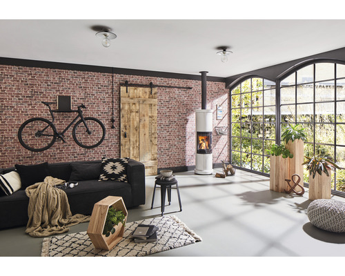 Salon avec canapé, poêle à bois, porte coulissante, fenêtre et éléments décoratifs pour une ambiance chaleureuse.