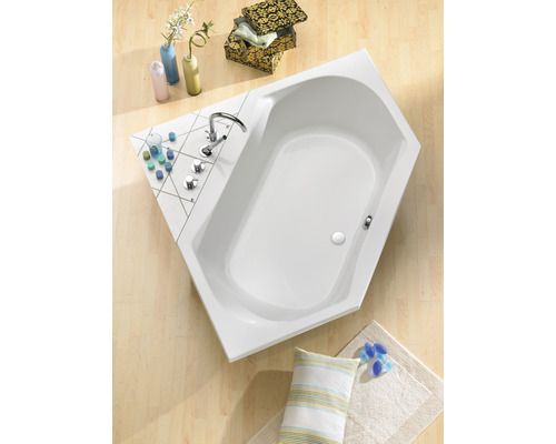 Baignoire d''angle dans la salle de bain avec robinetterie et objets de décoration sur le bord de la baignoire.