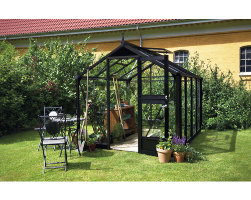 Serre avec outils de jardin et ensemble de table de jardin dans le jardin