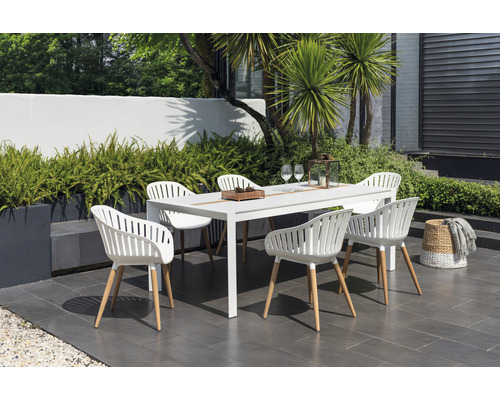 Scène de jardin avec une table à manger blanche et six chaises à l''extérieur