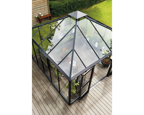 Serre aux parois de verre et cadre noir sur une terrasse en bois