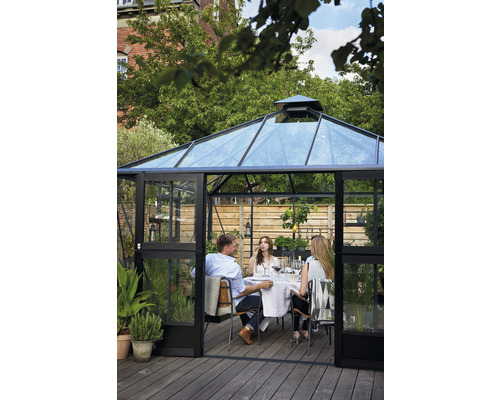 Serre aux parois transparentes avec un groupe de personnes attablées