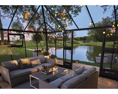 Serre avec coin salon et vue sur un lac