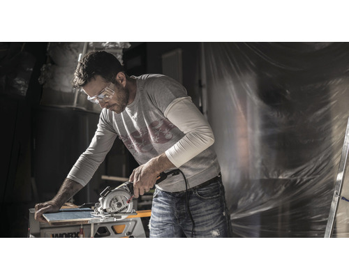Homme portant des lunettes de sécurité coupant une planche avec une scie circulaire Worx