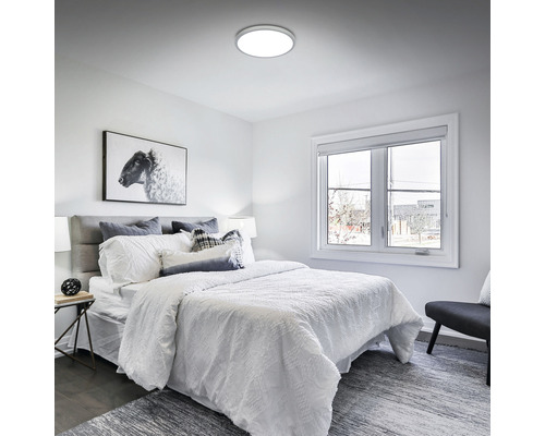 Schlafzimmer mit Deckenleuchte, Bett, Fenster und Dekorationen