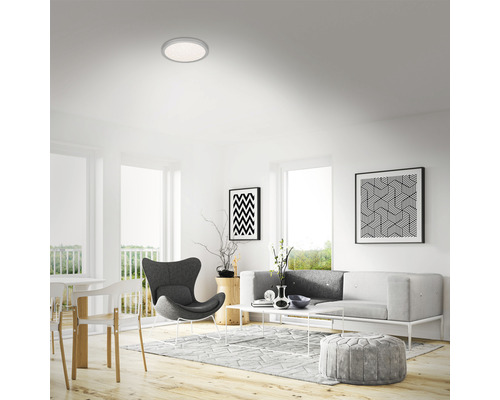 Wohnzimmer mit Deckenleuchte, Sofa, Sessel und Dekoration