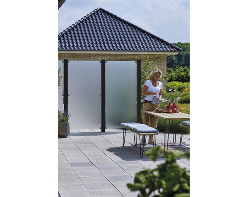 Terrasse avec éléments de protection visuelle, table, banc et femme