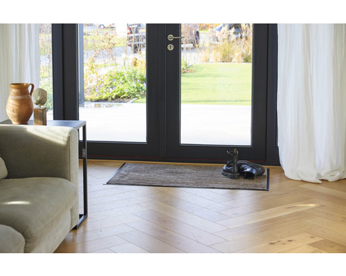 Paillasson devant une porte-fenêtre dans un espace de vie lumineux.