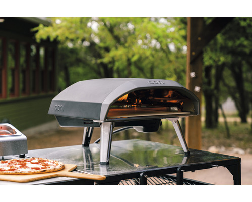 Ooni Pizzaofen mit Pizza auf einem Holzbrett