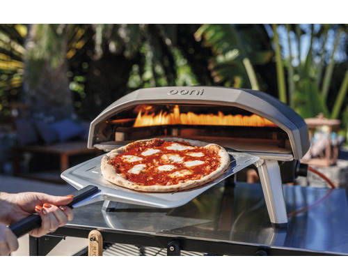 Ooni Logo. Pizza wird mit einem Pizzaschieber aus einem Pizzaofen geholt.