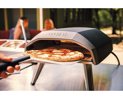 Logo Ooni sur four à pizza avec pizza sur pelle à pizza