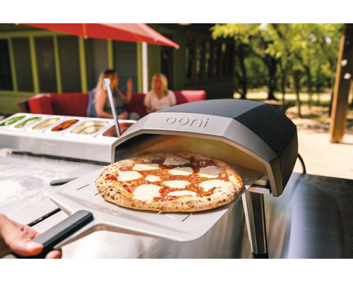 Four à pizza Ooni avec pizza sur pelle à pizza à l''extérieur