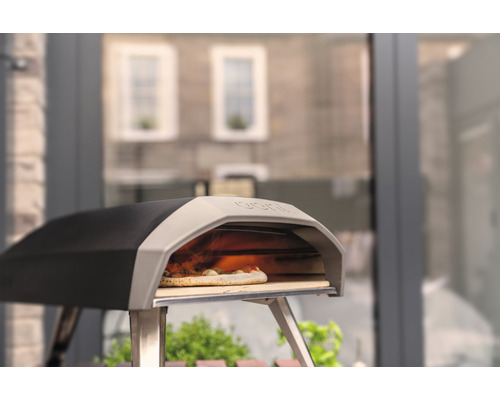 Four à pizza avec pizza sur une pierre à pizza