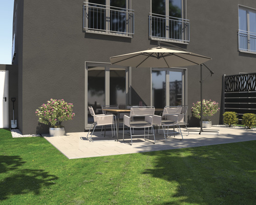Espace extérieur avec mobilier de terrasse sous un parasol devant une maison d''habitation