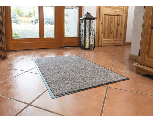 Paillasson dans l''entrée d''une maison sur un sol carrelé.