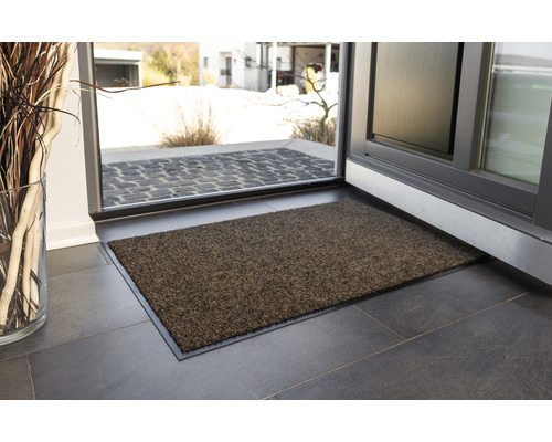 Paillasson devant une porte ouverte sur un sol carrelé