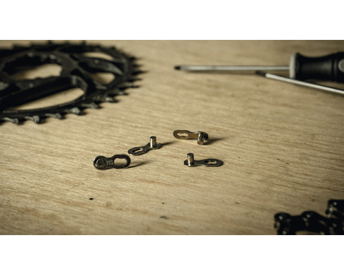 Chaîne de vélo, plateau et tournevis sur une surface en bois