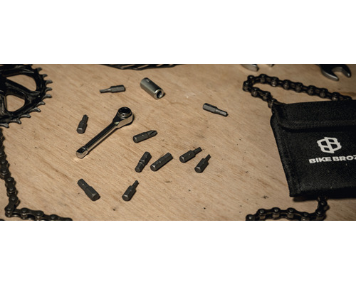 Kit d''outils pour vélo avec cliquet, embouts, fouet à chaîne et sac Bike Broz sur une table en bois