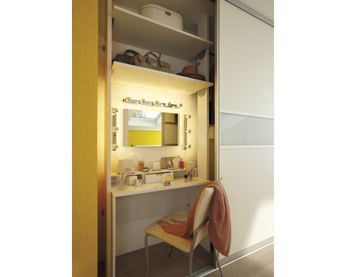 Ankleidezimmer mit Schminktisch, Spiegel und Beleuchtung in einem begehbaren Kleiderschrank.