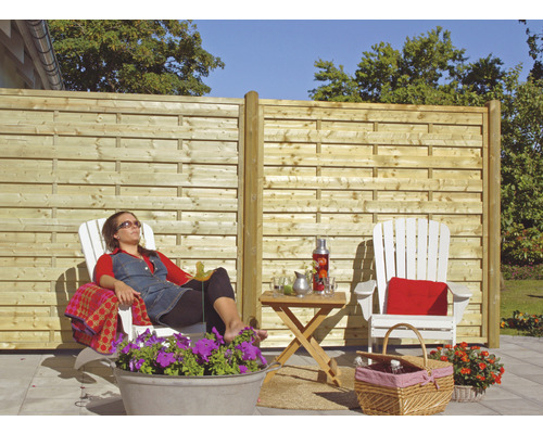 Jardin avec clôture en bois et personne détendue dans une chaise longue