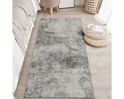 Tapis gris à motif abstrait dans une chambre.