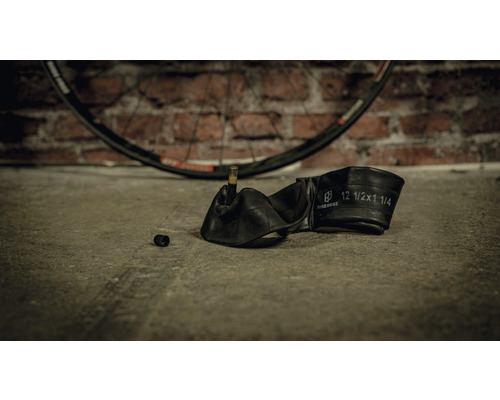 Fahrradschlauch mit Reifenmantel im Hintergrund