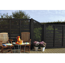 Gartenbereich mit Holzterrasse, Gartenmöbeln, Blumen und einem Zaun mit horizontalen Latten