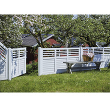 Gartenszene mit Holzzaun, Gartentor und Gartenbank auf einer Rasenfläche
