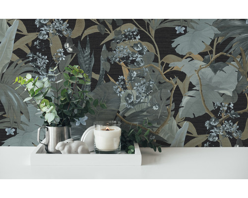 Scène décorative avec papier peint jungle, bougie, plante en pot et éléments de décoration sur un plateau.