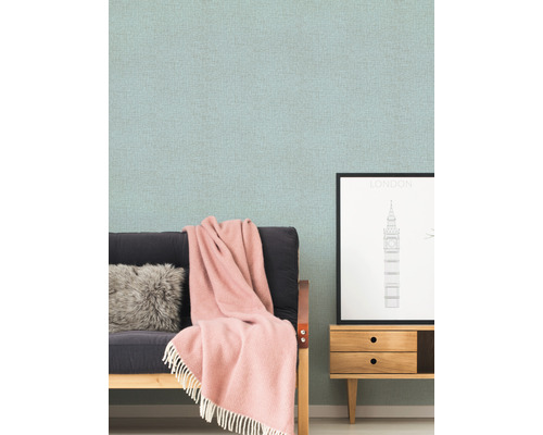 Scène de salon avec papier peint à motifs, canapé, coussin, couverture et commode