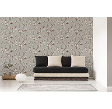 Salon avec un papier peint à motifs floraux et un canapé noir