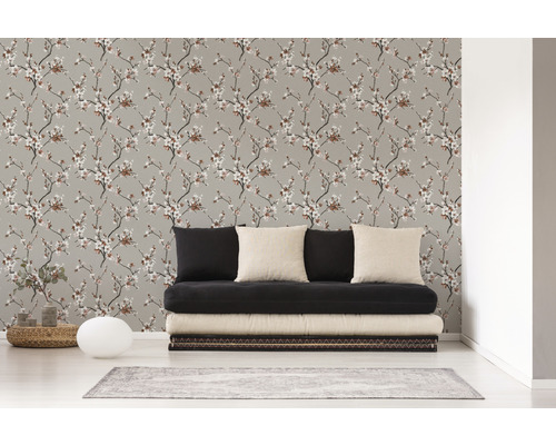 Salon avec un papier peint à motifs floraux et un canapé noir