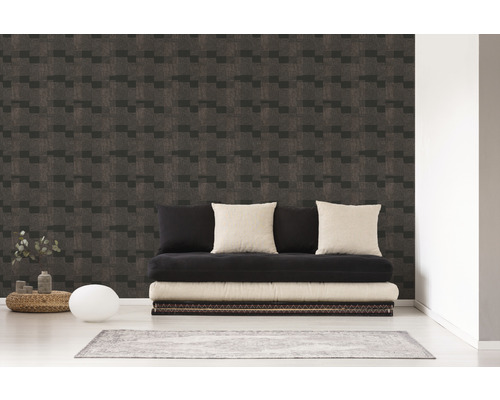 Salon avec un mur recouvert d''un papier peint à motifs géométriques et un futon noir