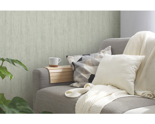 Wohnzimmer mit gemusterter Tapete, Sofa mit Kissen und Tagesdecke