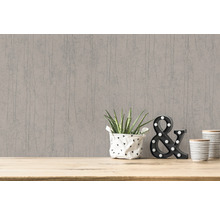 Tapete mit vertikalem Muster auf einer Wand mit dekorativen Elementen auf einem Holztisch