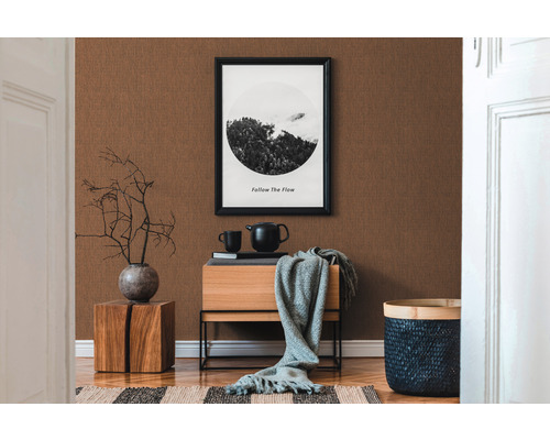 Dekoratives Zimmer mit brauner Tapete, Holzmöbeln und einer Schwarzweiß-Fotografie