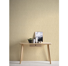 Ein helles Zimmer mit einer hellen, strukturierten Tapete hinter einem Holztisch mit Dekorationen