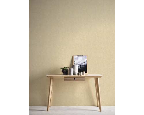 Ein helles Zimmer mit einer hellen, strukturierten Tapete hinter einem Holztisch mit Dekorationen
